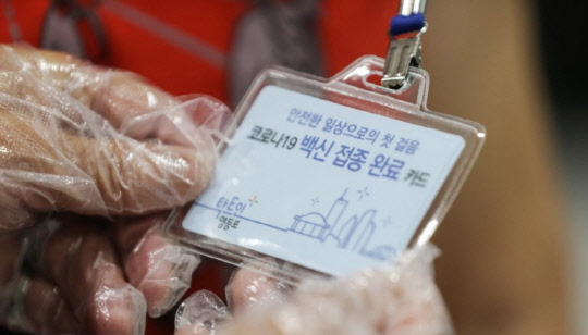 7일 오전 서울 영등포구 영등포아트홀에 마련된 코로나19 예방접종센터에서 한 어르신이 백신 접종 완료 카드를 보고 있다. (연합뉴스)